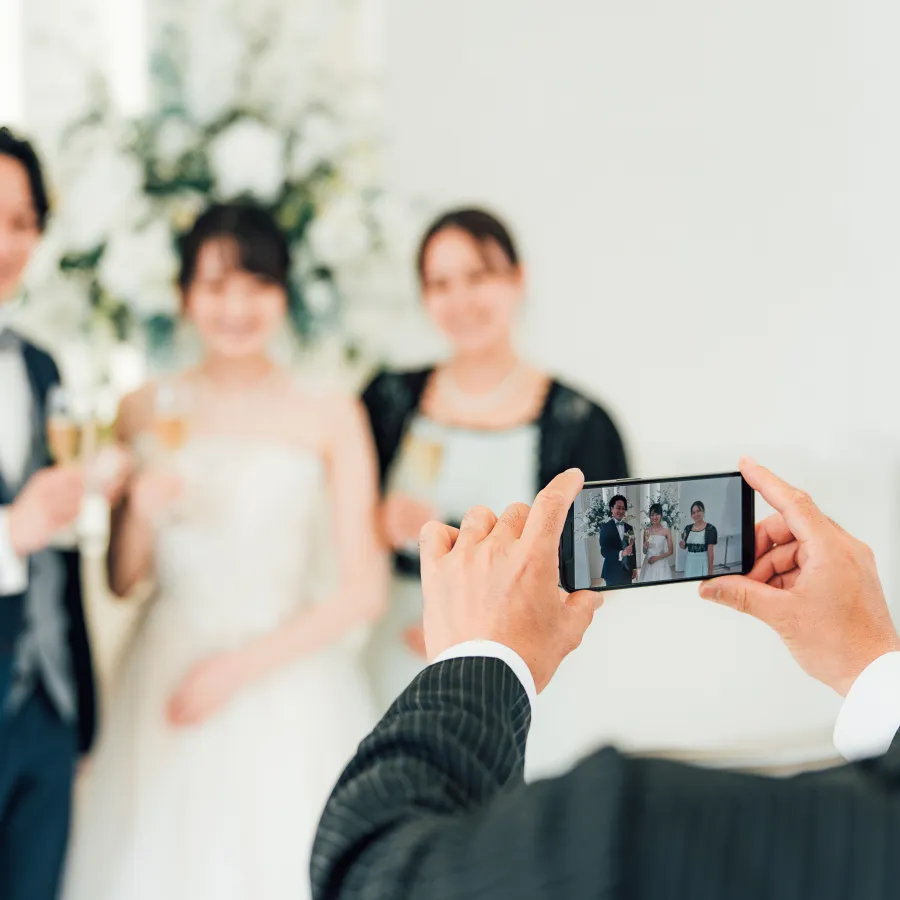 Invitado fotografiando a los novios con su celular durante la fiesta